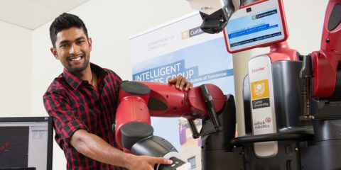 A male research student working on a robot