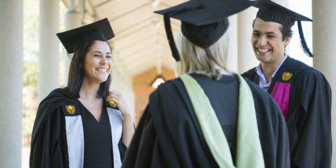 Group of Curtin university graduates in gowns laughing