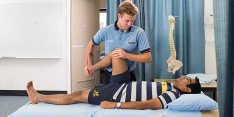A male physio student working on a male patient
