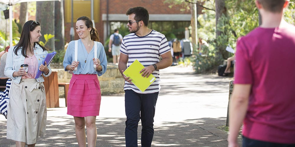 A group of students walking through the Curtin campus